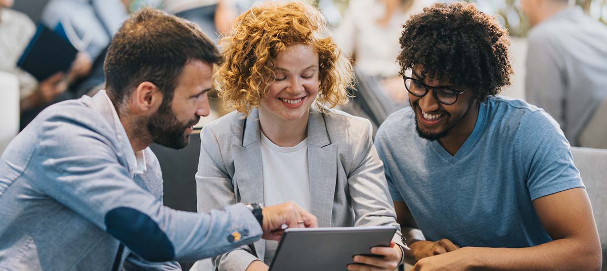 Image of 3 people discussing content on a laptop